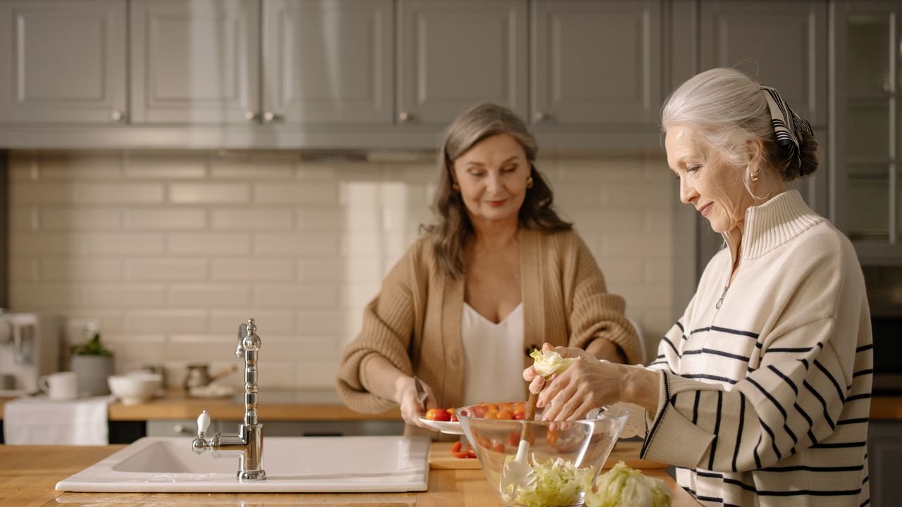 Two women preparing a fresh meal together in a bright kitchen