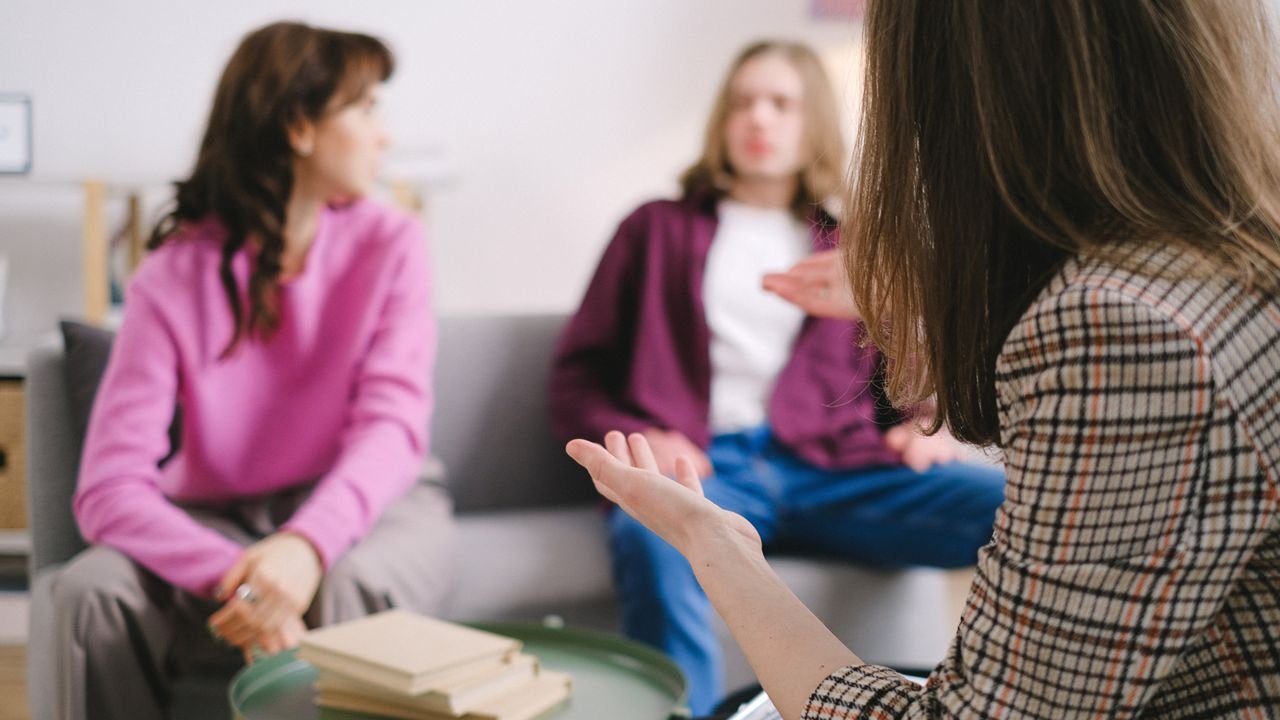 Three people talking together during a supportive counseling session