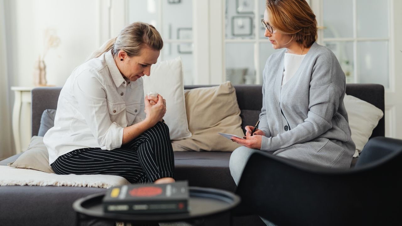 Three people in conversation during a supportive behavioral session at home