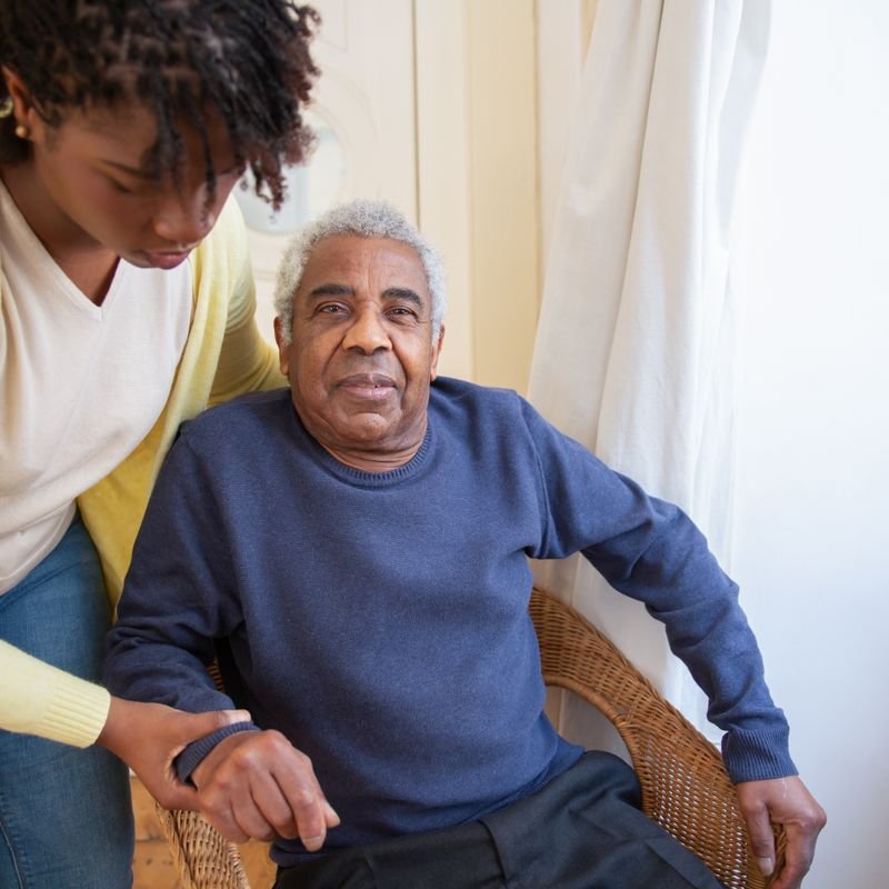 A support worker sitting and chatting with an older man at home